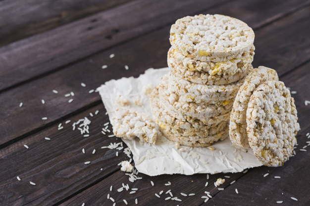 Pile of puffed rice cakes on brown wooden table Free Photo