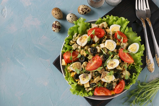 Premium Photo | Organic salad with chicken, cherry tomatoes, quail eggs, black olives and microgreens against on light blue surface, healthy eating day, top view