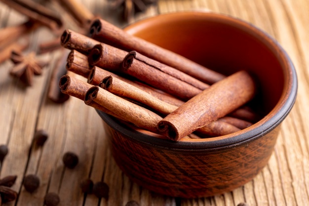 Free Photo | High angle of bowl with cinnamon sticks and defocused star anise